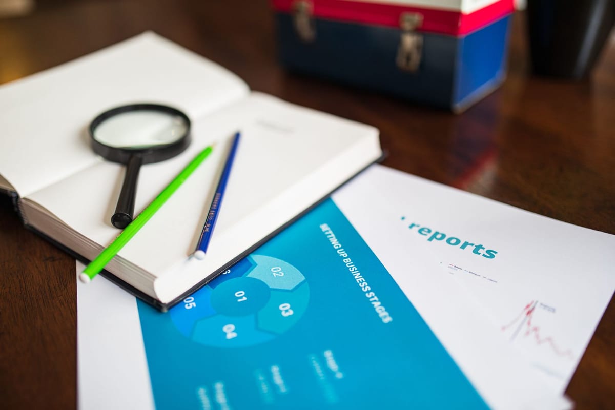 An open book and a magnifying glass on a desk — working through the rules in the text of the laws